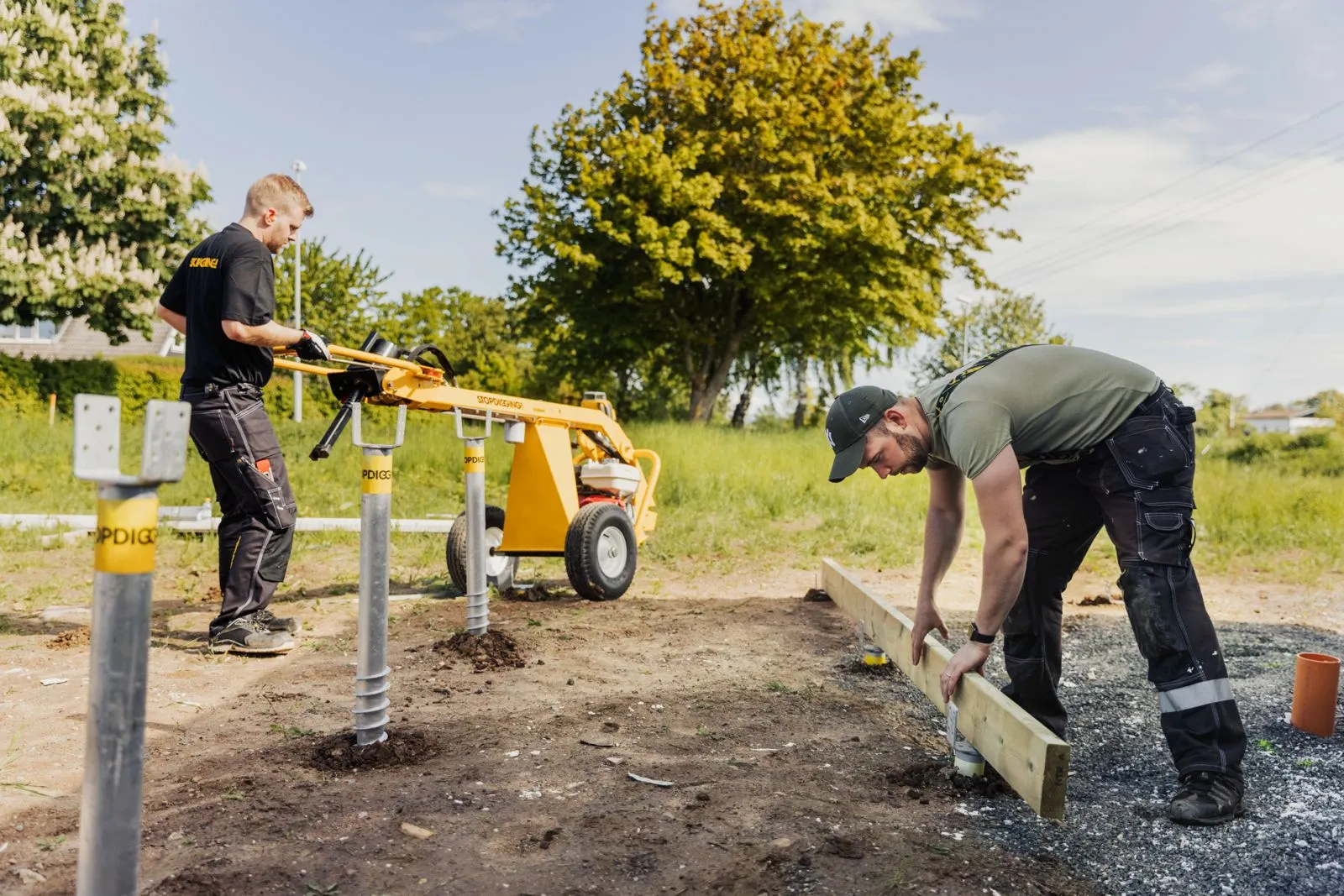 Crown Pavilions team installing ground screws with hydraulic equipment
